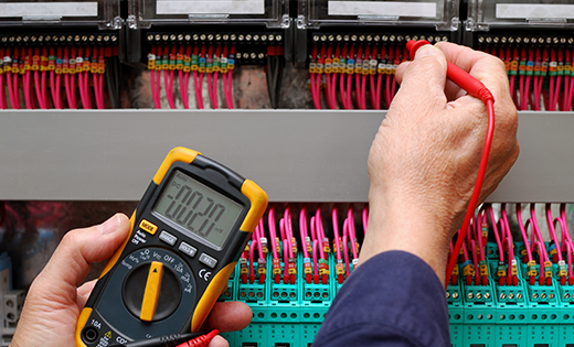 Man testing electrical current of circuit board - Electrician Sunshine Coast