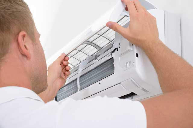 Man repairing a white air conditioner - Air Conditioner Sunshine Coast